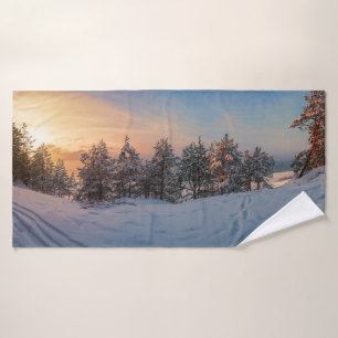 Sonnenuntergang über gefrorenem Schneewald in der Badehandtuch