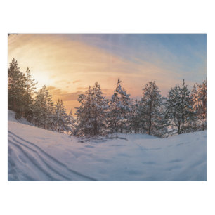 Sonnenuntergang über gefrorenem Schneewald in der Tischdecke