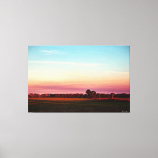 Sonnenuntergang über grünem Feld Leinwanddruck