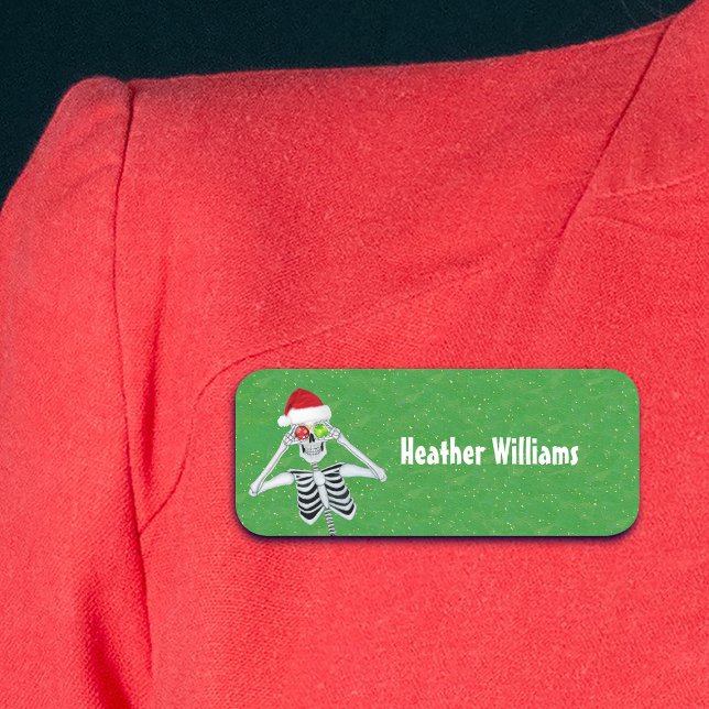Spaß Weihnachten Skeleton Ornaments Hat grünes Gol Namensschild (Cute Christmas skeleton holding ornaments to eyes on green gold plastic name tag.)