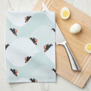 Spielerische Pinguine, die auf dem Schneepattern g Geschirrtuch