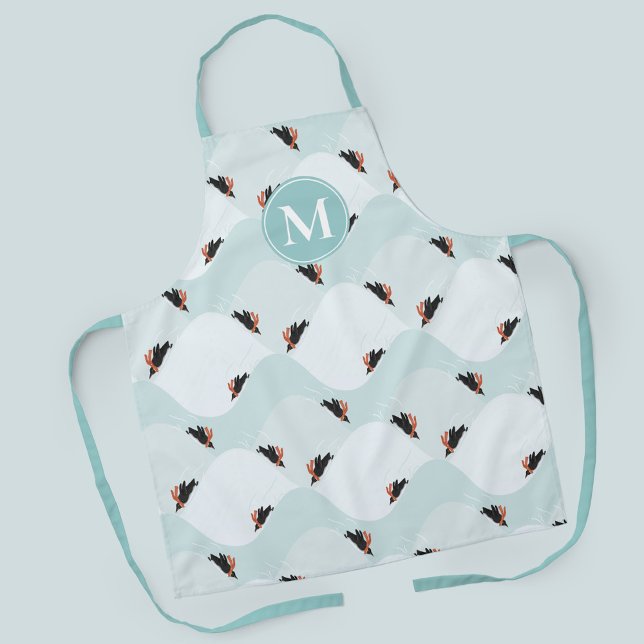 Spielerische Pinguine, die auf dem Schneepattern g Schürze (Penguins sledding in the snow patterned apron with customizable monogram)