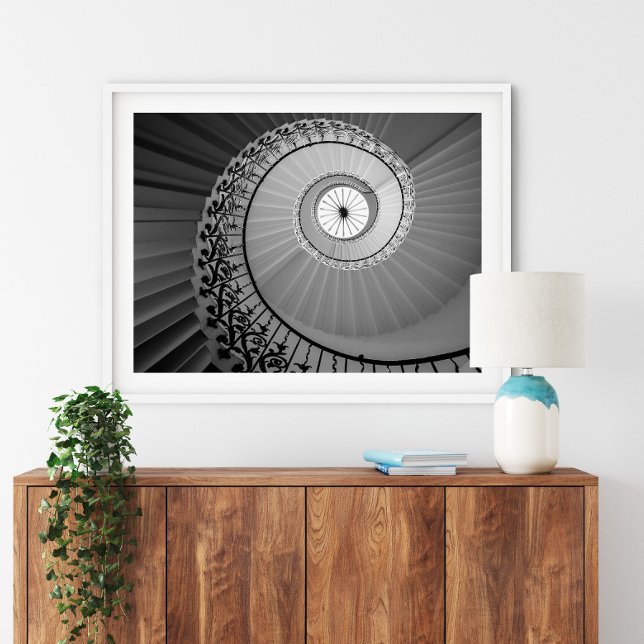 Spiraltreppe mit Blume Poster (Spiral Staircase with Flowers Poster in a white frame above a small furniture.)