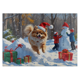 Spitz läuft im Schnee mit Weihnachtshut Schneidebrett