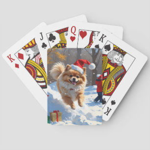 Spitz läuft im Schnee mit Weihnachtshut Spielkarten