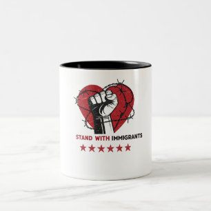 STAND MIT EINWANDERERN ZWEIFARBIGE TASSE