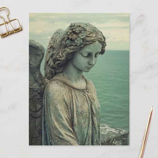 Statue Serene Angel mit Patina Postkarte (Postcard featuring an angel statue covered in patina, laid flat on a marble surface.)