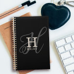Stilvoller Name mit Kalligrafie Monogram Black Planer<br><div class="desc">Stilvoll und schön präsentiert dieses Monogramm-Design den ersten Vornamen in einem einfachen Serif-Schriftart und einem eleganten Kalligraphie-Schriftart im Hintergrund. Ihr Name wird in diesem einzigartigen typografischen benutzerdefinierten Design unter Ihrem Monogramm angezeigt. Die drei Elemente vereinen sich mit einer ausgeklügelten Harmonie und kreieren Ihr persönliches Logo, das stilvoll und weiblich ist....</div>