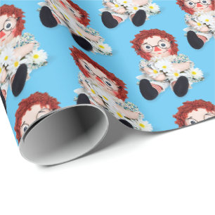 Stoffpuppe mit Gänseblümchen auf Blau Geschenkpapier