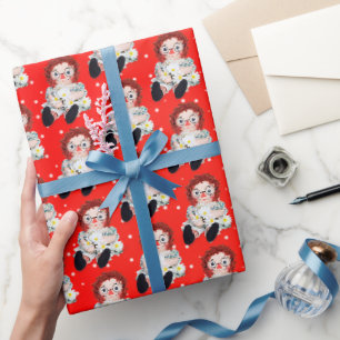 Stoffpuppe mit Gänseblümchen auf Punkten Geschenkpapier