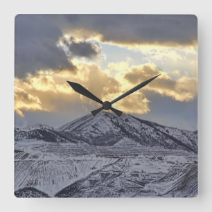 Sturmsonne über schneebedeckte Berge Quadratische Wanduhr
