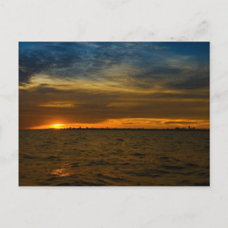 Sun, der hinter der Stadt aufzeichnet Postkarte