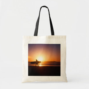 Surfen mit Surfbrett am Strand bei Sunset Tragetasche