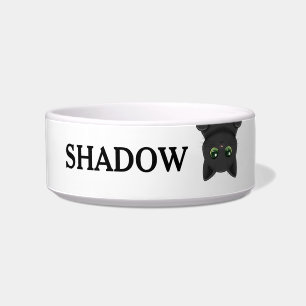 Süße auf dem Kopf stehende schwarze Katze mit indi Napf