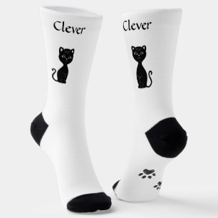 Süße lustige schwarze Katze und Pfoten auf weißen Socken