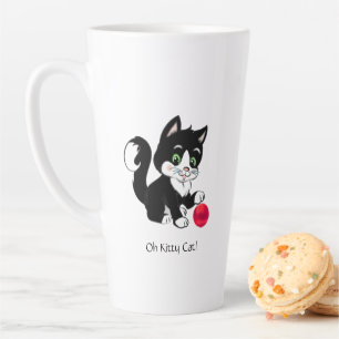 Süße schwarze und weiße Tuxedo-Katze mit rotem Bal Milchtasse