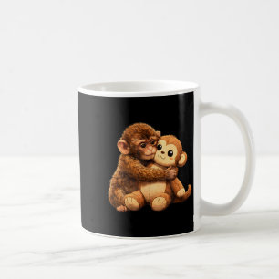 Süßer Affenliebhaber, süßes Babyäffchen, das umarm Kaffeetasse