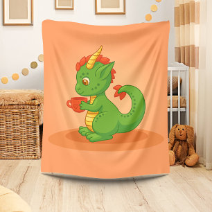 Süßer Baby-Drache hält Tasse auf Orange Fleecedecke