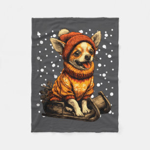 Süßer Weihnachts-Chihuahua beim Schlittenfahren im Fleecedecke