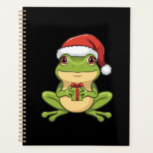 Süßer Weihnachtsfrosch mit Santa-Hut, der ein Gesc Planer