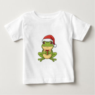 Süßer Weihnachtsfrosch mit Santa-Hut hält Geschenk Baby T-shirt