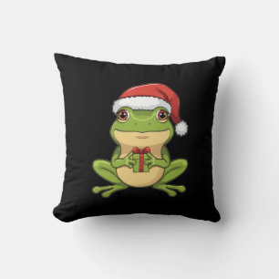 Süßer Weihnachtsfrosch mit Santa-Hut hält Geschenk Kissen