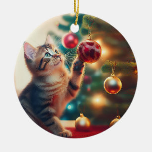Süßes kleines Kätzchen spielt mit Weihnachtszwiebe Keramik Ornament