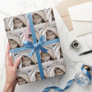 Tabby Cat versteckt sich unter einer Decke Geschenkpapier