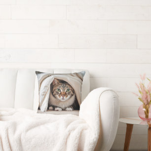 Tabby Cat versteckt sich unter einer Decke Kissen