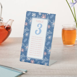 Tabelle mit dunkelblauen und weißen Blumenbestuhlu Sockelschild