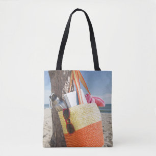 Tasche, die am Baum-Stamm an Sandy-Strand hängt