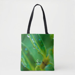 Tasche mit Regentropfen auf grünen Blättern