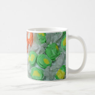 Tasse mit Süßigkeiten aus grünem und orangefarbene