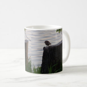 Tasse mit Vogel auf einem Baumstumpf