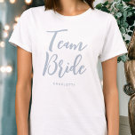 Team Bride Wedding Personalisiert Dusty Blue T-Shirt<br><div class="desc">Feiern Sie mit diesem personalisierten T - Shirt Ihre Braut! Die Wörter 'Team Bride' sind in einem trendigen Script-Schriftart geschrieben und unten können Sie einen individuelle Name, ein Hochzeitdatum, einen Ort oder einen anderen Text hinzufügen. Ein schönes Geschenk für einen Junggeselinnen-Abschied, Polterabend oder Feiertag Wochenende! Farben: staubiges Blau und Weiß....</div>