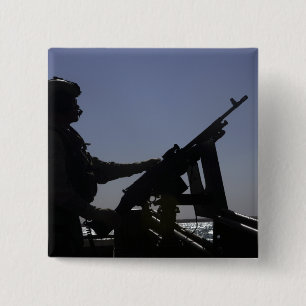 Techniker, der ein Maschinengewehr M240 im Irak Button