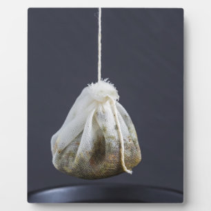 Teebeutel hängt in einer Tasse Fotoplatte