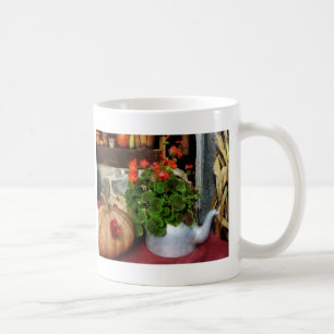Teekanne gefüllt mit Pelargonien Tasse
