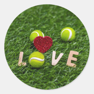 Tennisball mit Liebe auf grünem Gras Runder Aufkleber