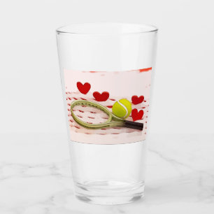 Tennisschläger mit Ball und roter Liebe Glas