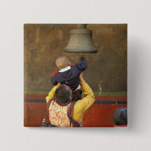 Tibetischer buddhistischer Mönch hebt einen Jungen Button