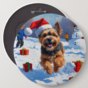 Tibetischer Terrier läuft im Schnee mit Weihnachts Button