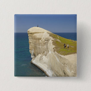 Touristen auf der Klippe oben in Tunnel Beach Button