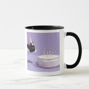 Tragender Geburtstagshut der Katze, der heraus an Tasse