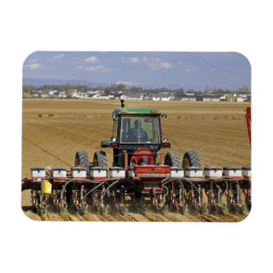 Traktor zieht eine Mais-Sämaschine. Magnet