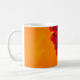Traube aus blauen Trauben in orangem Neonlicht. Le Kaffeetasse