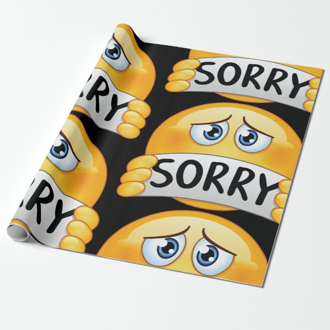 Trauriges Sorry Emoji Gesicht hält Entschuldigungs Geschenkpapier (Ungerollt)