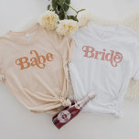 TRIXIE Retro 70's Themed Groovy Babe Bachelorette T-Shirt<br><div class="desc">Dieses babe bachelorette t Shirt ist mit einem Retro-Schriftart im Stil der 70er Jahre in cremefarbenen Orangenfarben gestaltet. Bestellen Sie die Weiße Braut Option für die Braut und die orangefarbenen "Babe" Shirts für Ihre Bachelorette Gruppe. Farben sind bearbeitbar! Klicken Sie auf 'Design bearbeiten',  um Ihre eigenen Farben zu erstellen.</div>