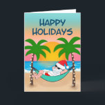 Tropical Beach Santa Hammock Palm Tree Feiertagskarte<br><div class="desc">Die Weihnachtskarte zum Thema Tropical und Küstenweihnachtszeit lädt zum Entspannen in einer Hängematte am Strand ein. Hier genießen Sie die Meereswellen und den bunten Sonnenuntergang und die festlichen Palmen, die in Strandlichter verziert sind. Cover Gruß sagt "Happy Holidays" in marineblau. Innen Gruß und der Name kann personalisiert sein (zeigt mit...</div>