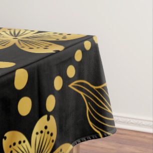 tropische Blätter und Blume in Gold auf schwarz Tischdecke